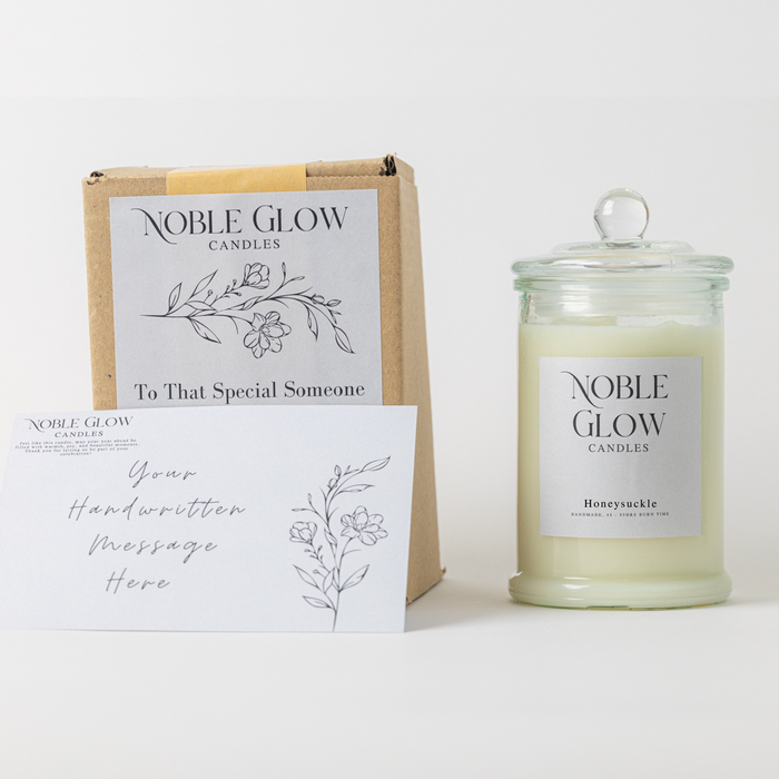 Noble Glow candles with packaging and card on a white background