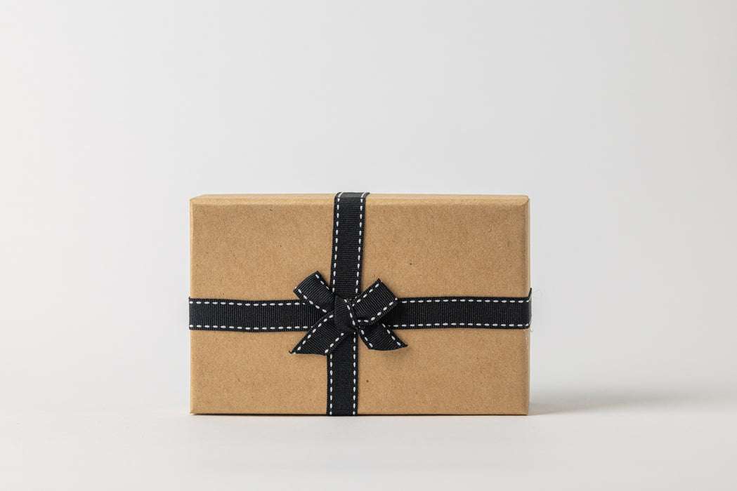 Kraft paper gift box with a black ribbon on a white background