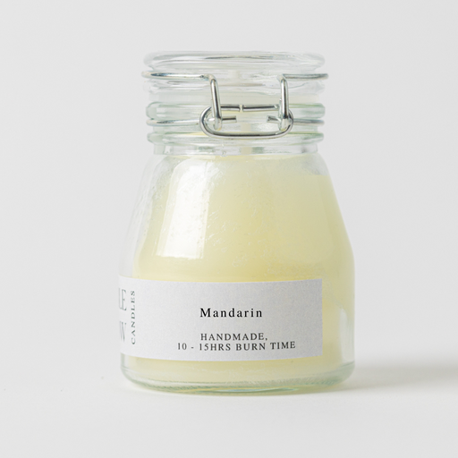 Glass candle jar labeled 'Mandarin' with a white background