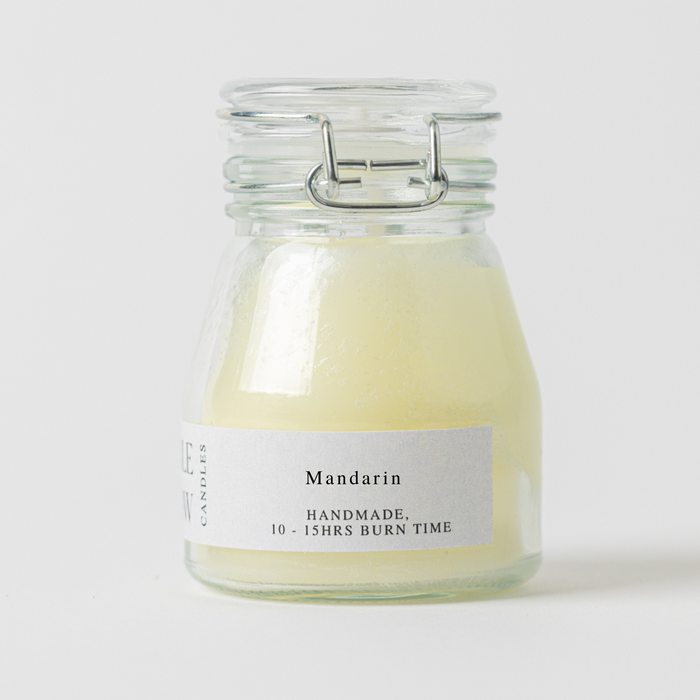 Glass candle jar labeled 'Mandarin' with a white background